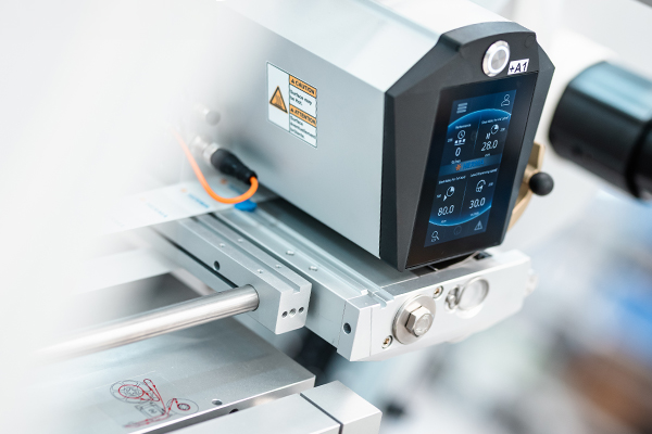 Ein präzises Bedienfeld einer Maschine mit digitalen Anzeigen für Temperatur und Druck, montiert auf einer Metallstruktur.