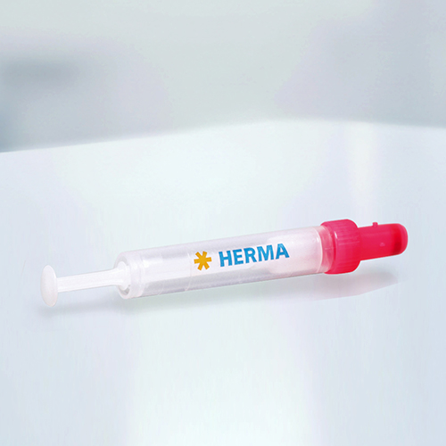 一支红色盖子的注射器，上面写着“HERMA”，背景是明亮的。