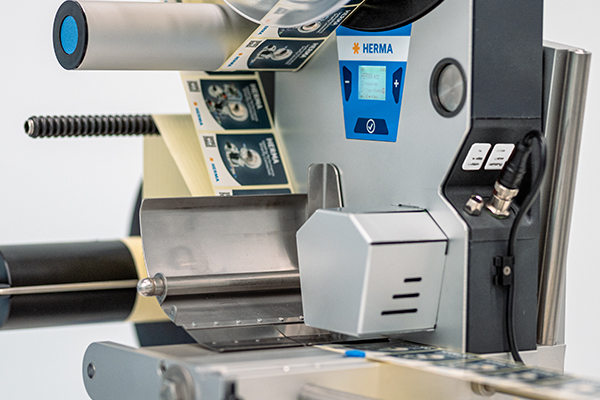 Etikettiermaschine mit digitalem Display und laufendem Etikettenband. Die Maschine ist für die Etikettierung von Produkten konzipiert.