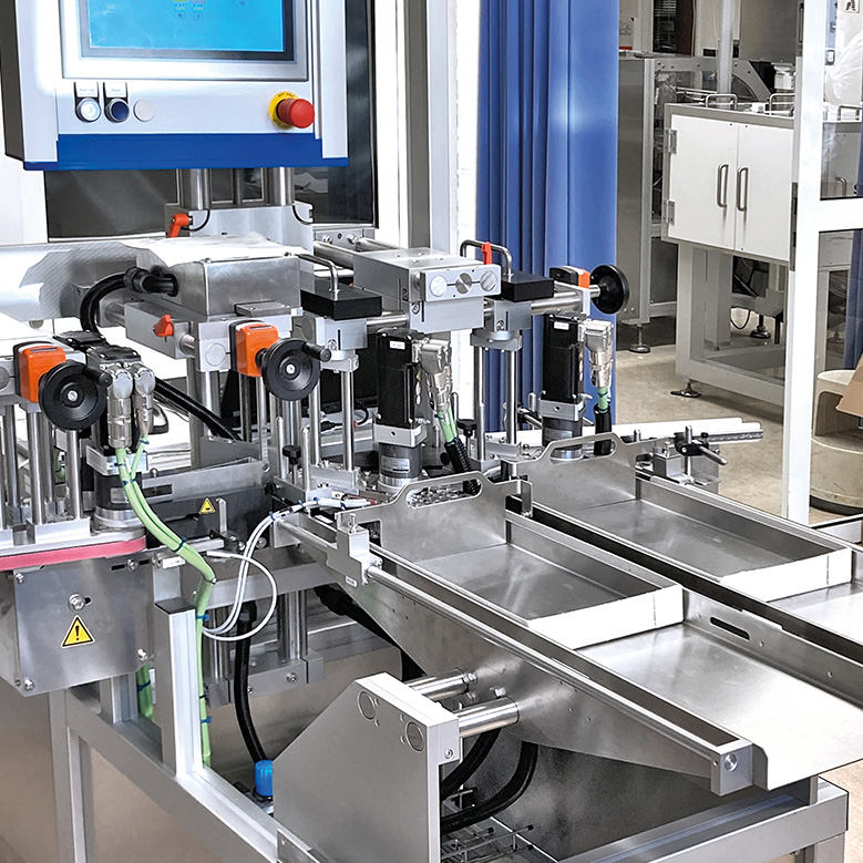 Automatisierte Maschinenanordnung mit mehreren Greifarmen und Steuerungseinheit, die für industrielle Fertigungsprozesse konzipiert ist.