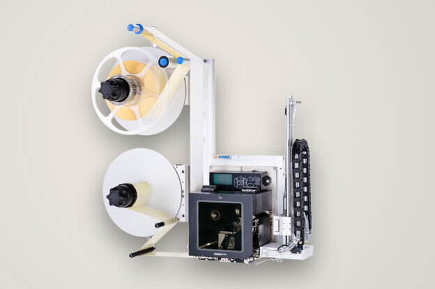 Ein Gerät mit zwei Spulen, einem Druckmechanismus und verschiedenen Steuerungselementen, das für die Verarbeitung von Papier oder Etiketten verwendet wird.