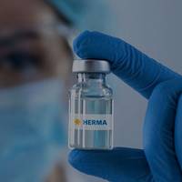 Eine Person mit blauen Handschuhen hält eine kleine Glasflasche mit der Aufschrift "HERMA".