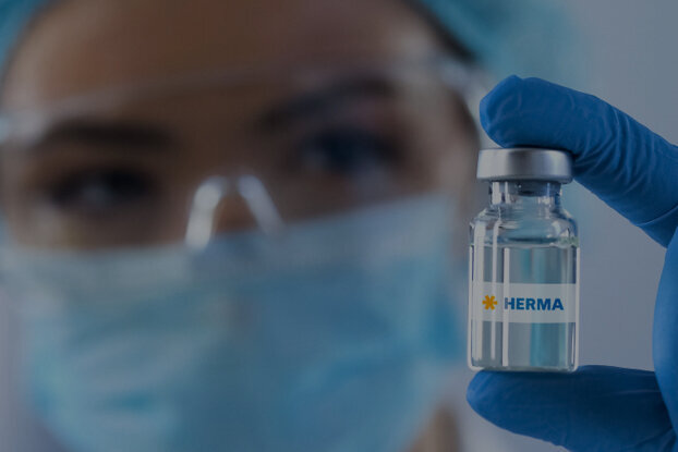 Eine Person in Schutzkleidung hält eine Impfstoffflasche mit dem Etikett "China" in der Hand.